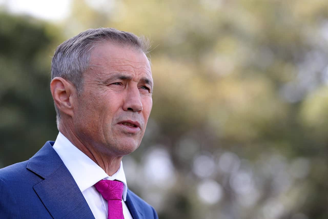 Roger Cook wearing a blue suit and pink tie