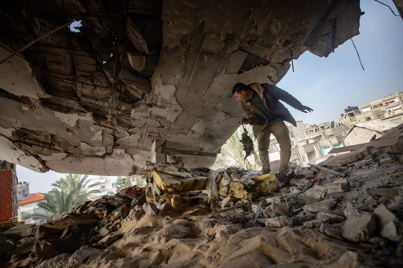  A man checks the damages inside the family home after an Israeli air strike.