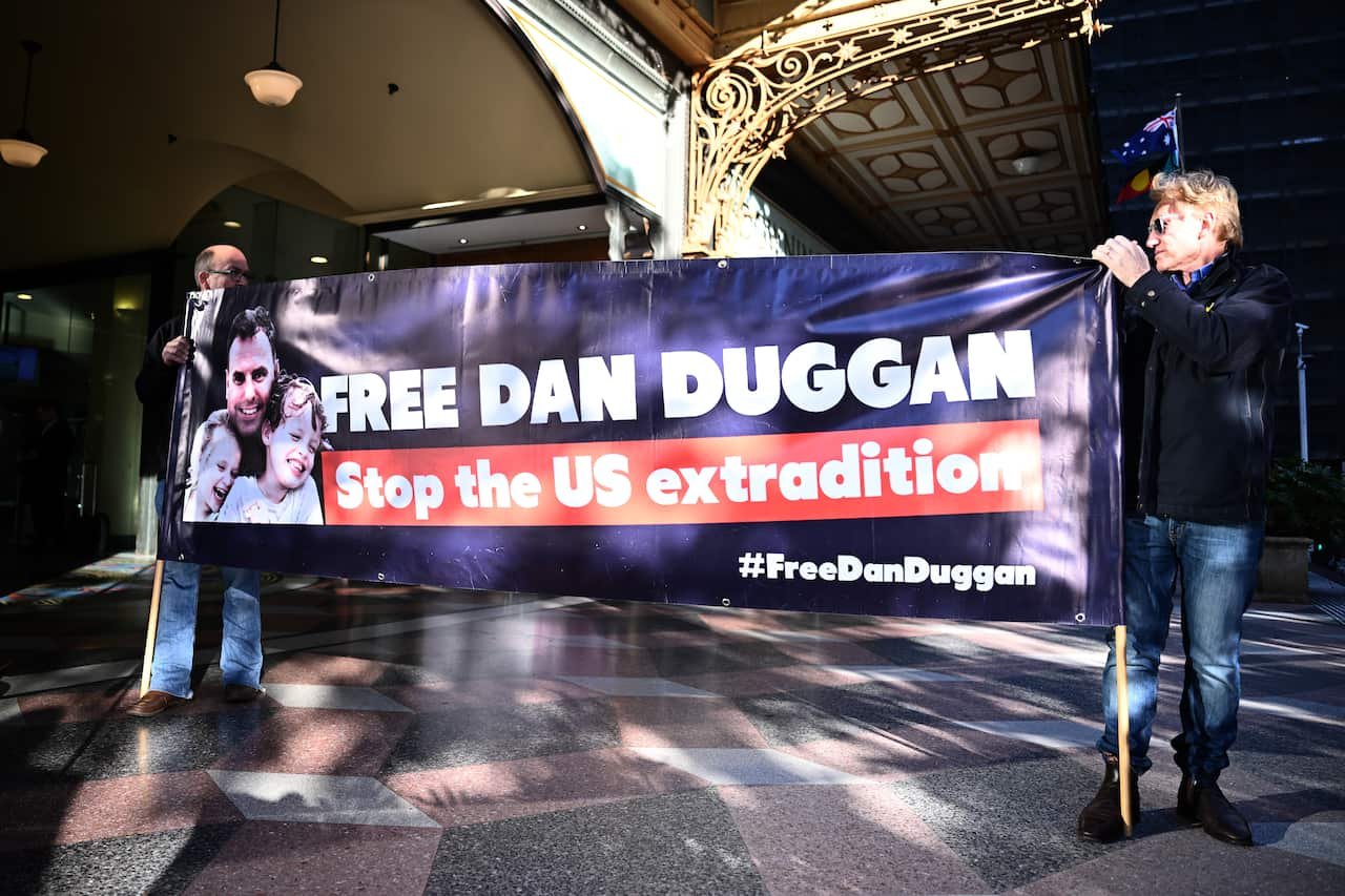 Supporters of former US Marine Daniel Duggan stand with a banner calling for his extradition to the United States to be stopped. 