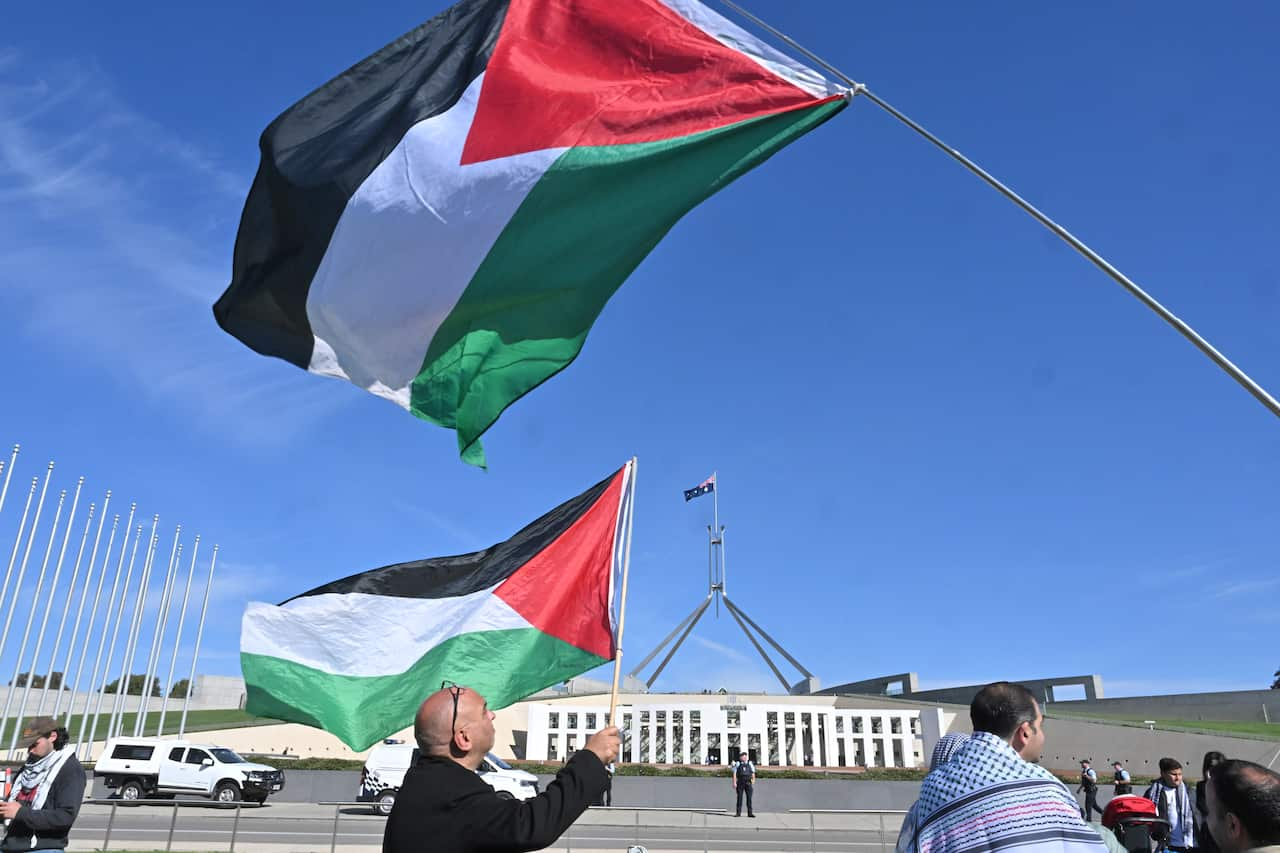 Two flags fly outside a building