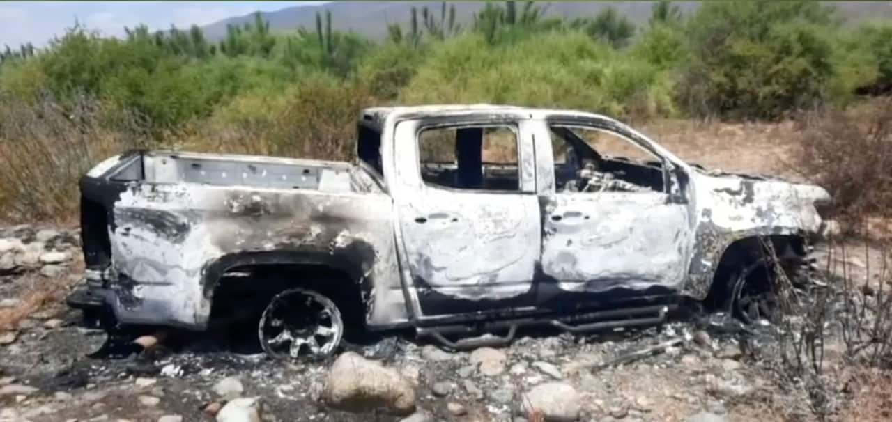 A burnt out white ute.