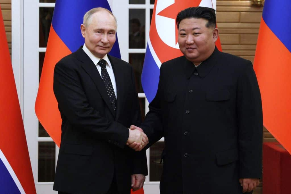 Russian President Vladimir Putin and North Korea's Kim Jong Un shake hands.