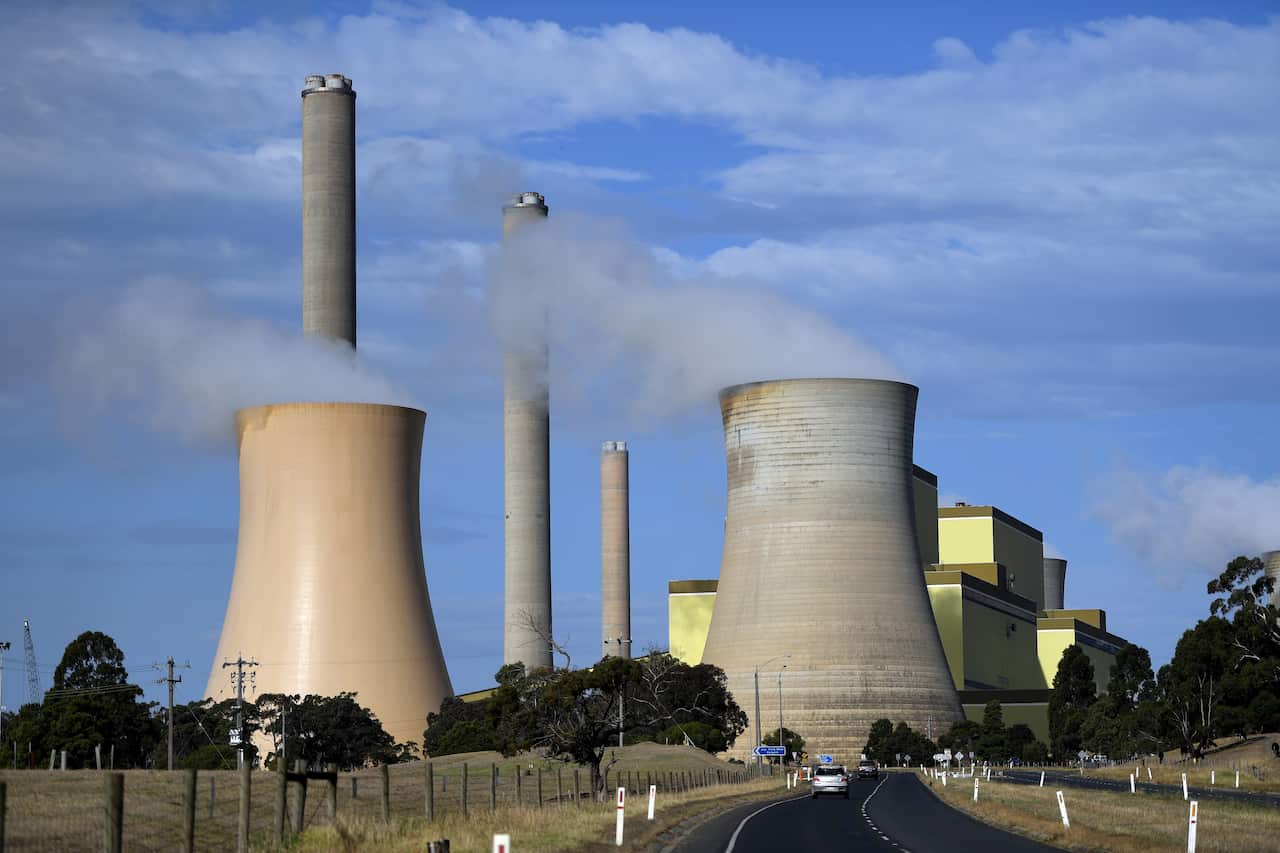 A coal-powered plant with smoke coming out.