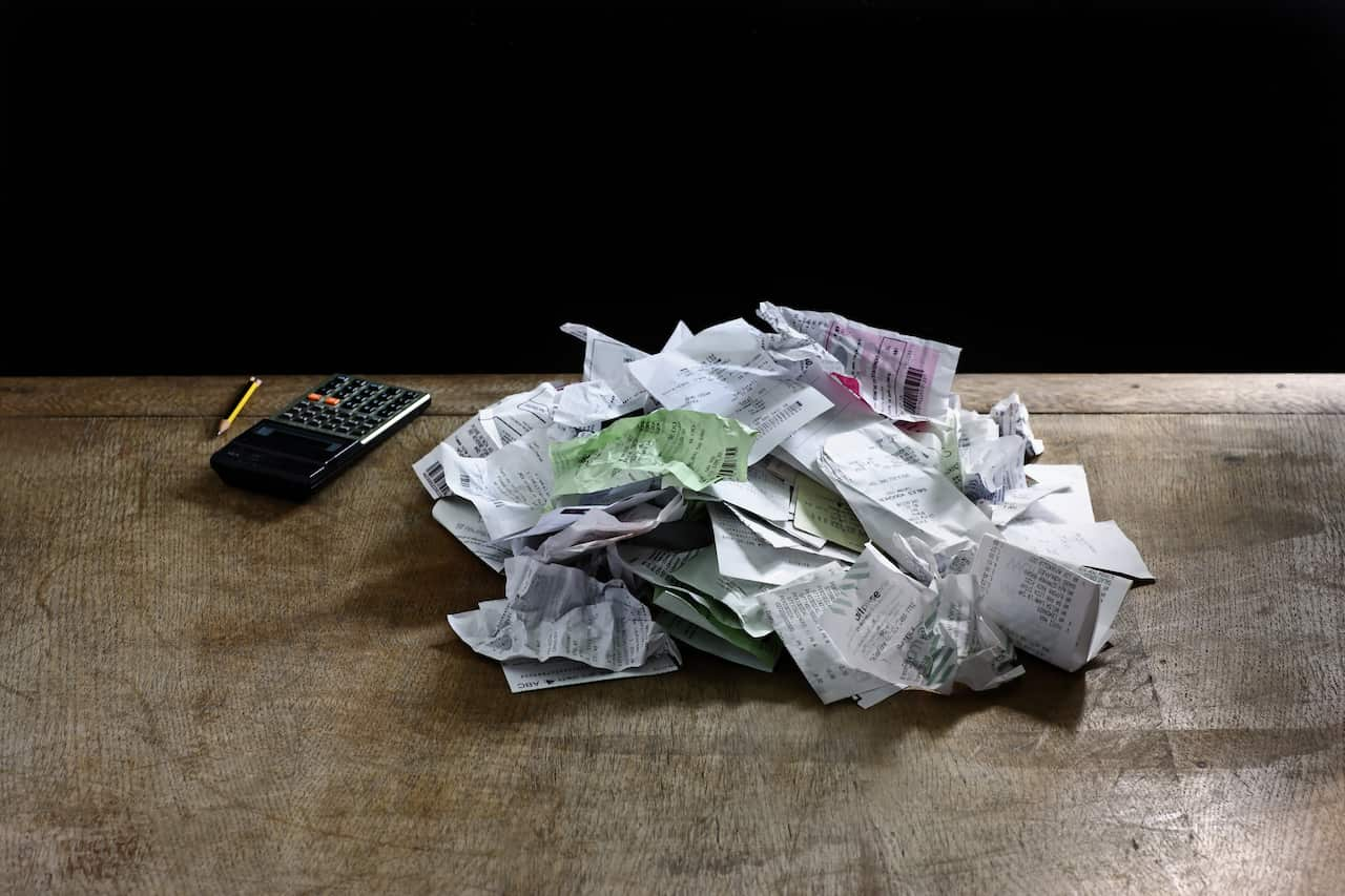 A pile of receipts next to a calculator.