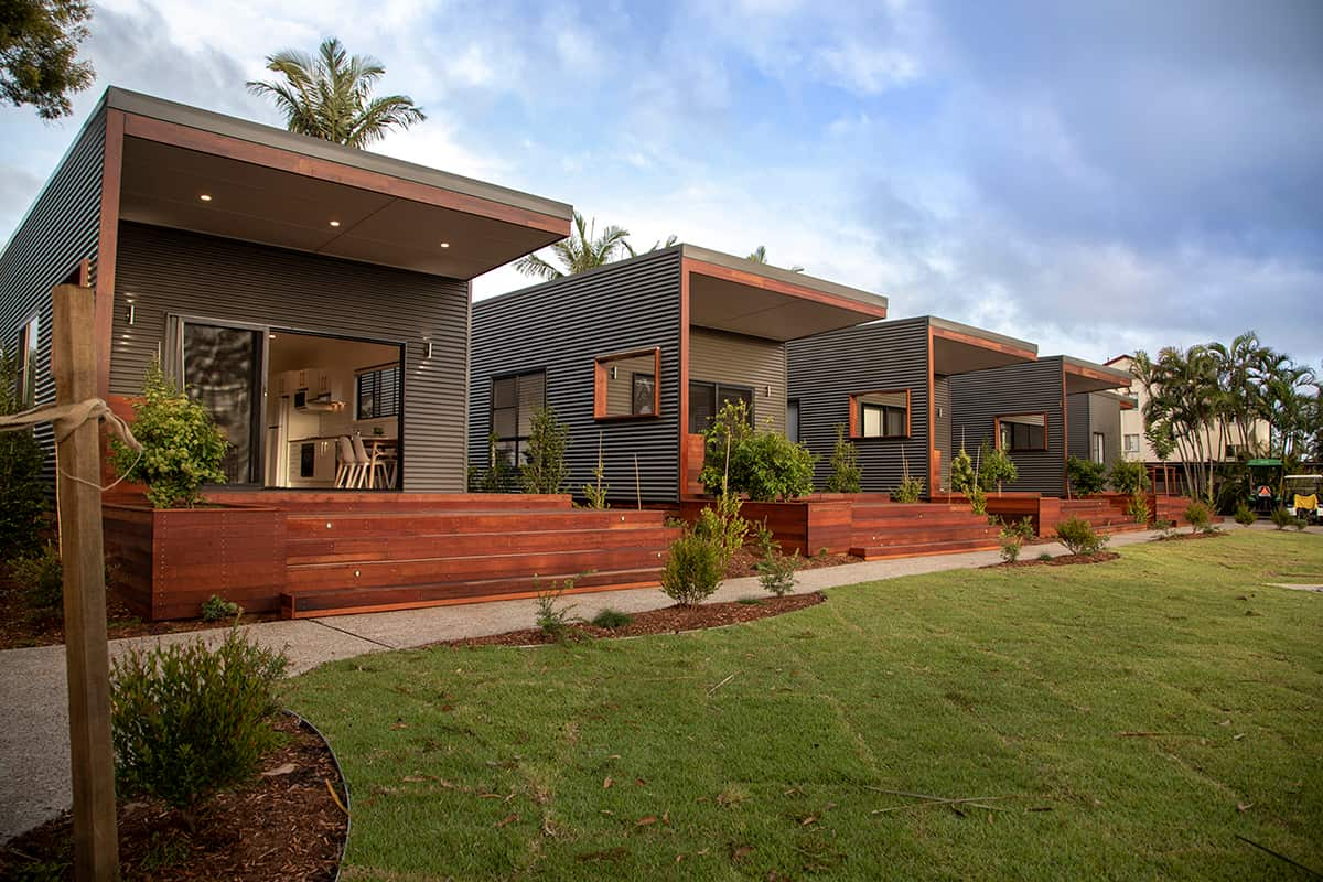 Three homes with timber decking sit side-by-side