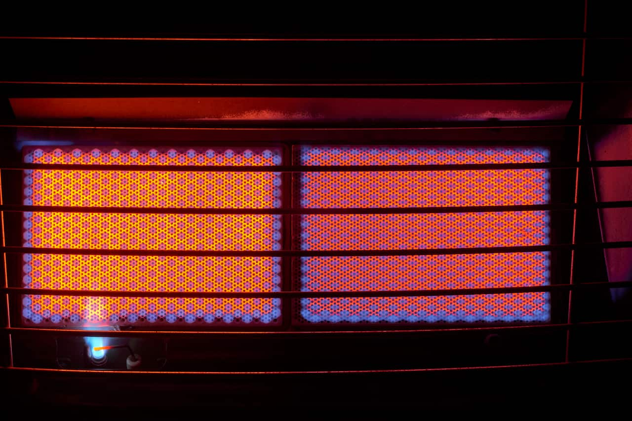 A gas heater turned on, with glowing orange light coming from it.