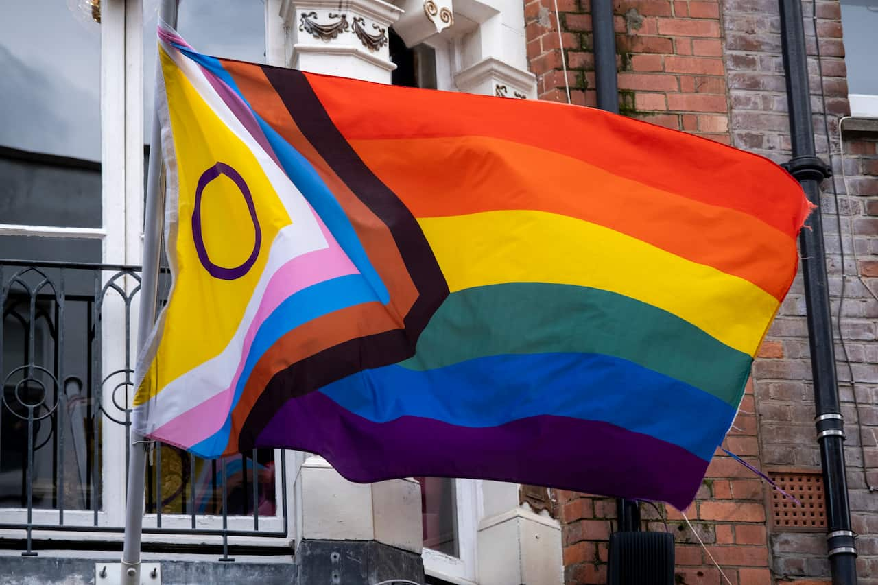 An LGBTIQ+ pride flag, with all the colours of the rainbow, including other coloured stripes and a circle for other parts of the community.