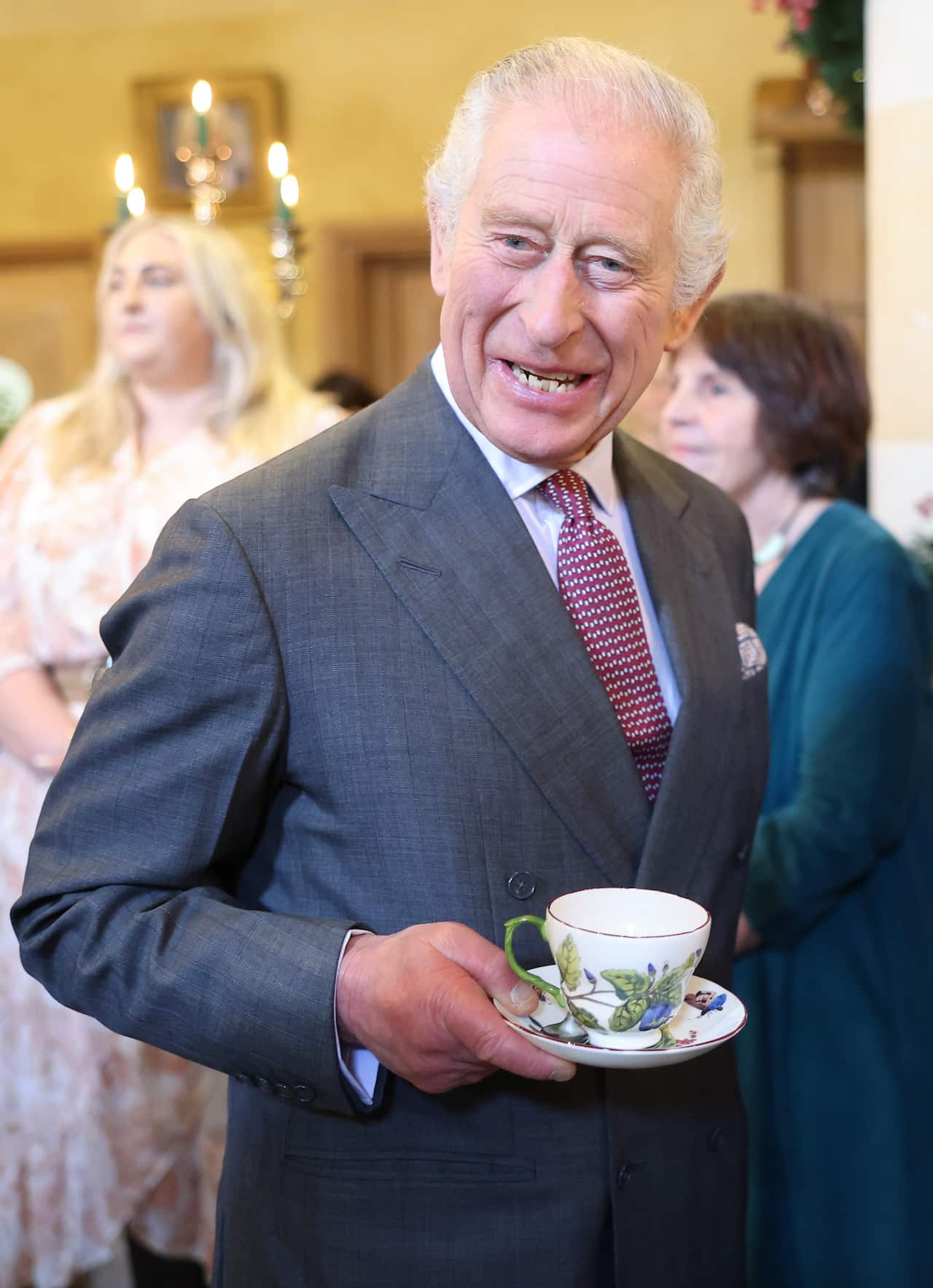 King Charles holding a tea cup and saucer