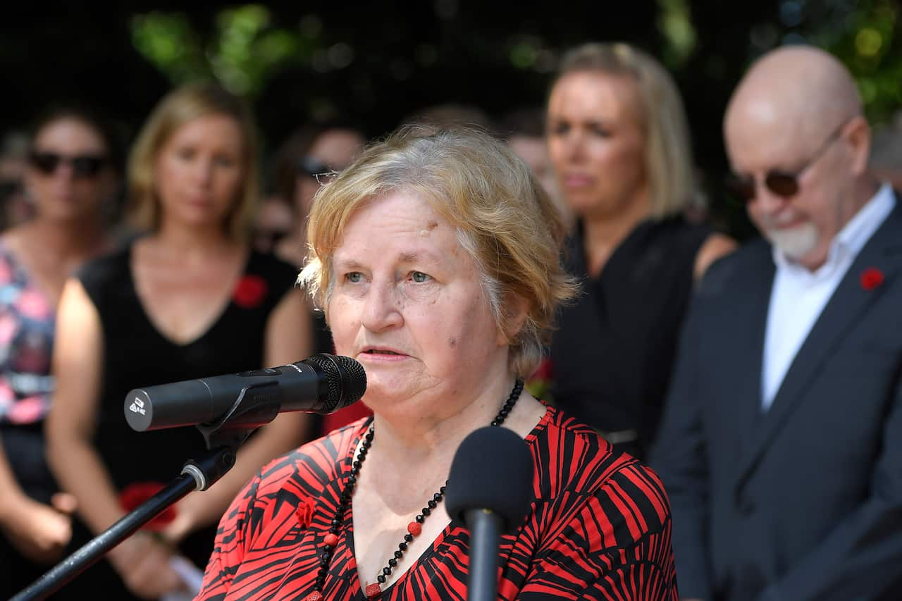 A woman speaks from behind a microphone