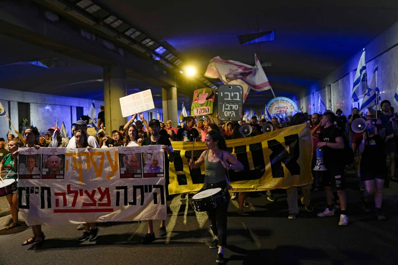 A group of protesters march down the street.