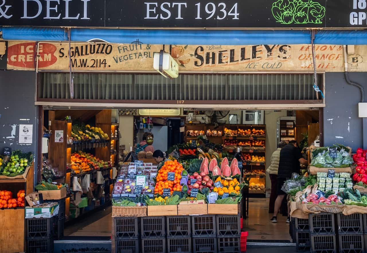 A street view of a fruit shop its original signage and establishment date of 1934.  