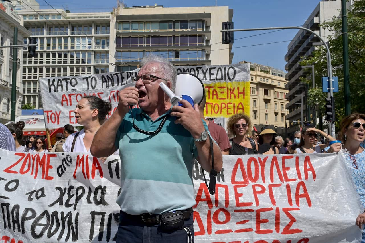 A man shouts into a megaphone at a protest.