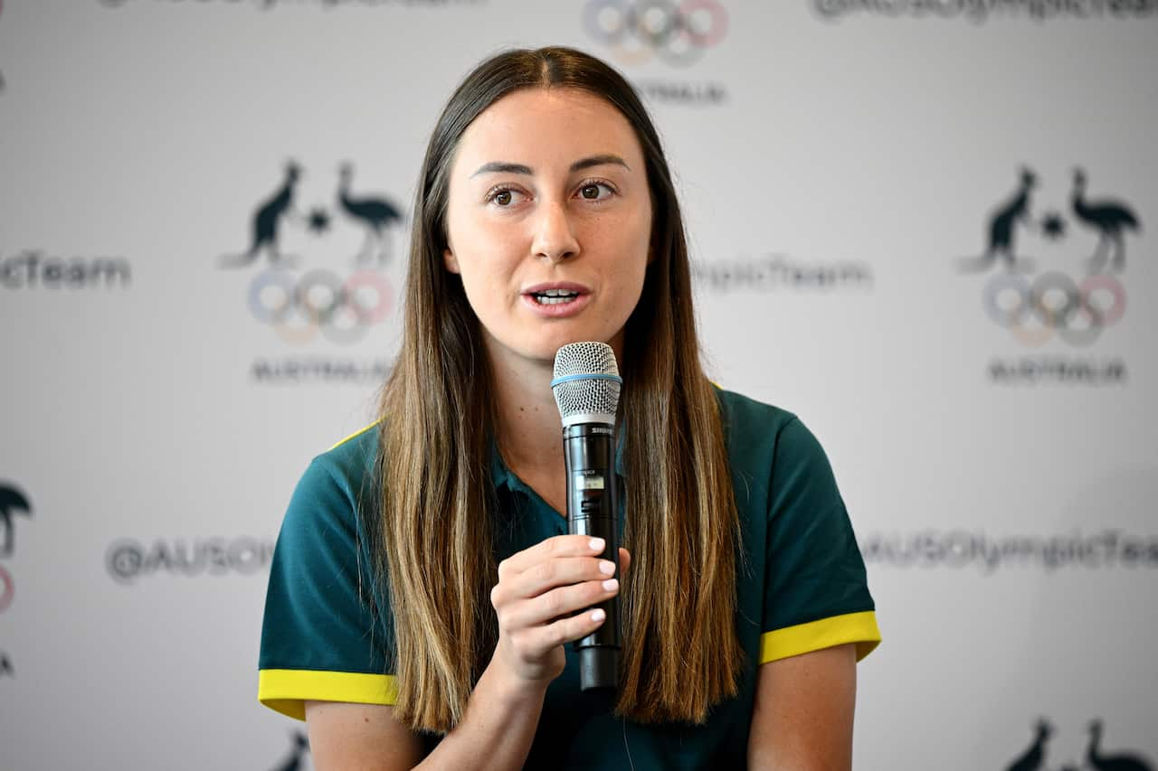 A woman in a green polo shirt holding a microphone