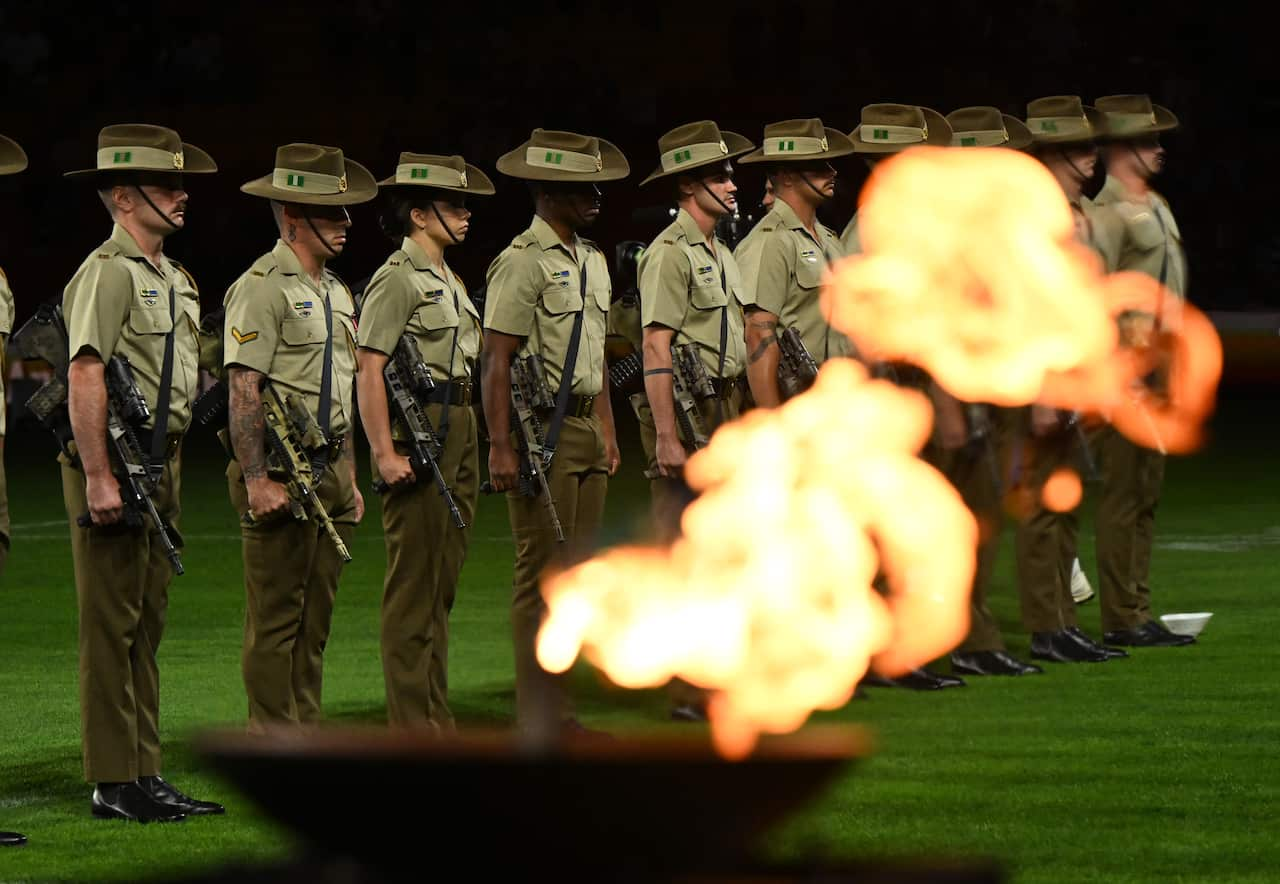 A row of soldiers standing on a green ground. 