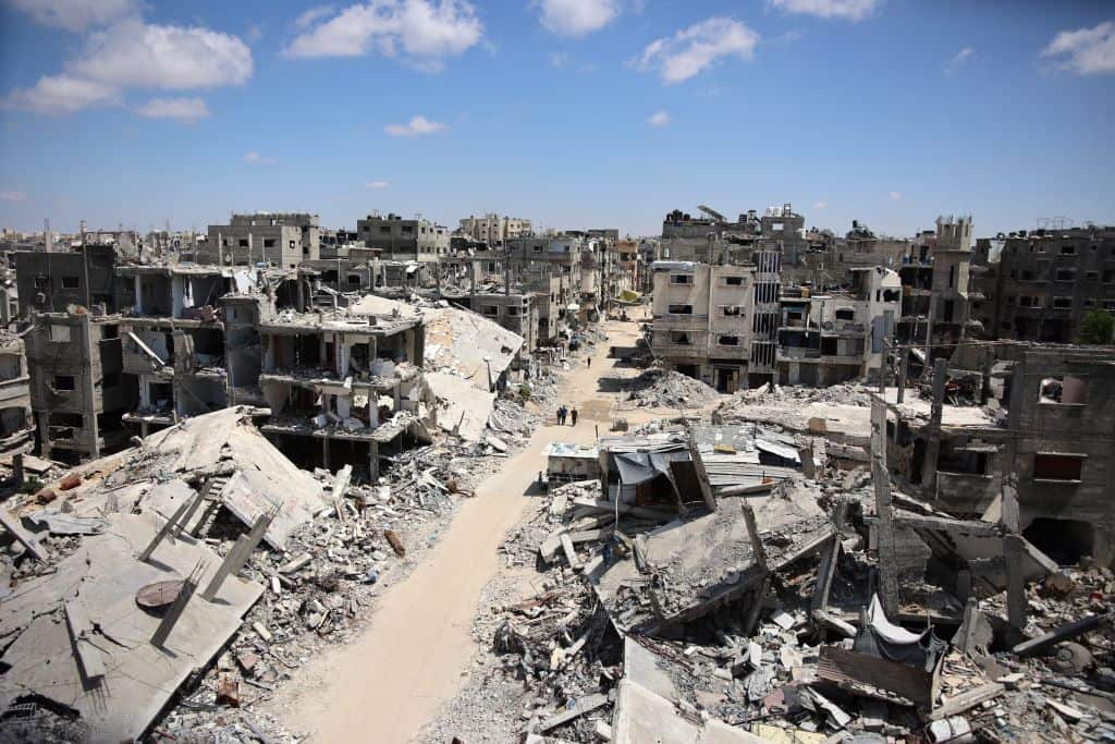 A view of a street destroyed by war, with buildings turned to rubble.