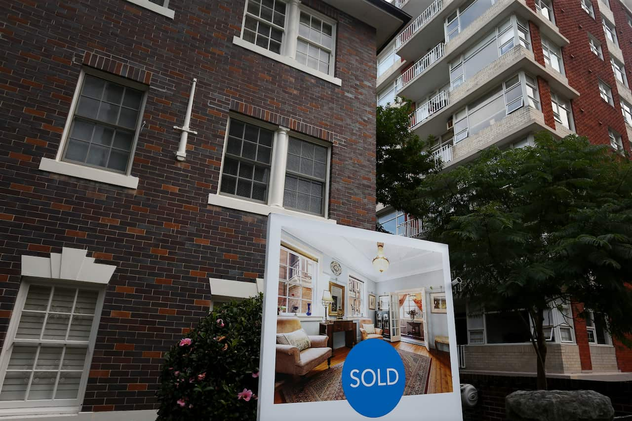 a sold sign outside a block of apartments