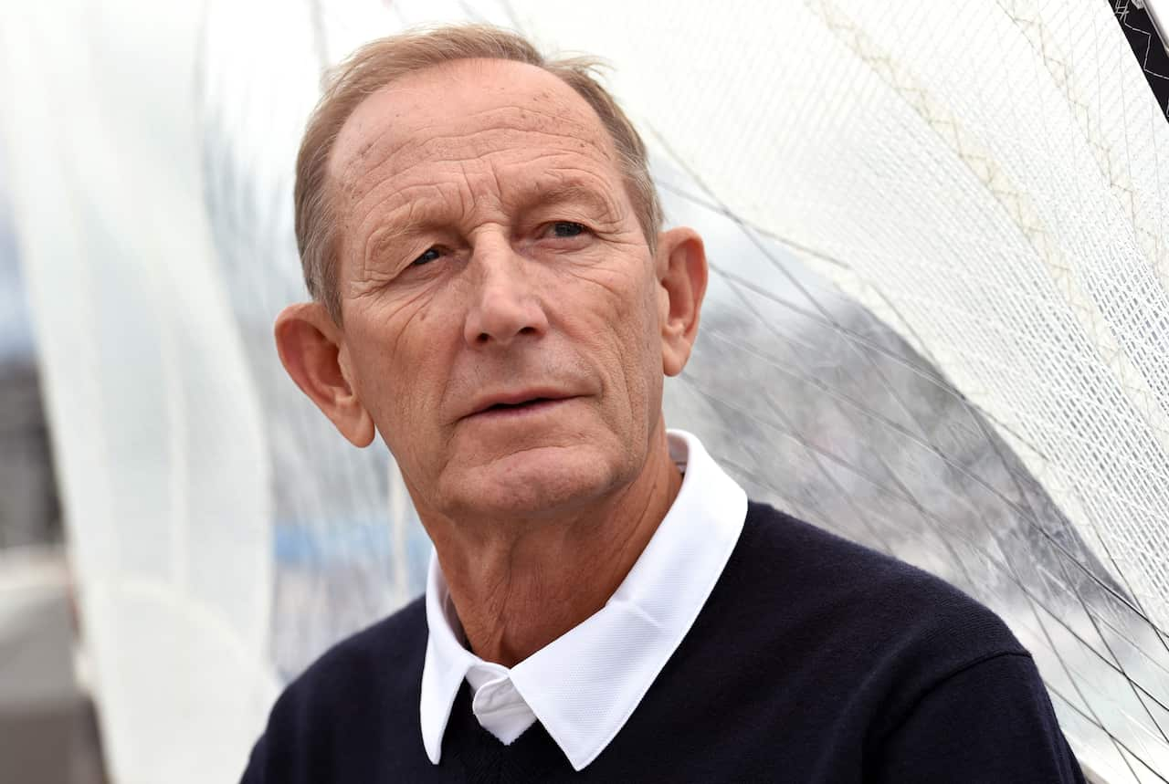 A man in a white collared shirt and dark jumper