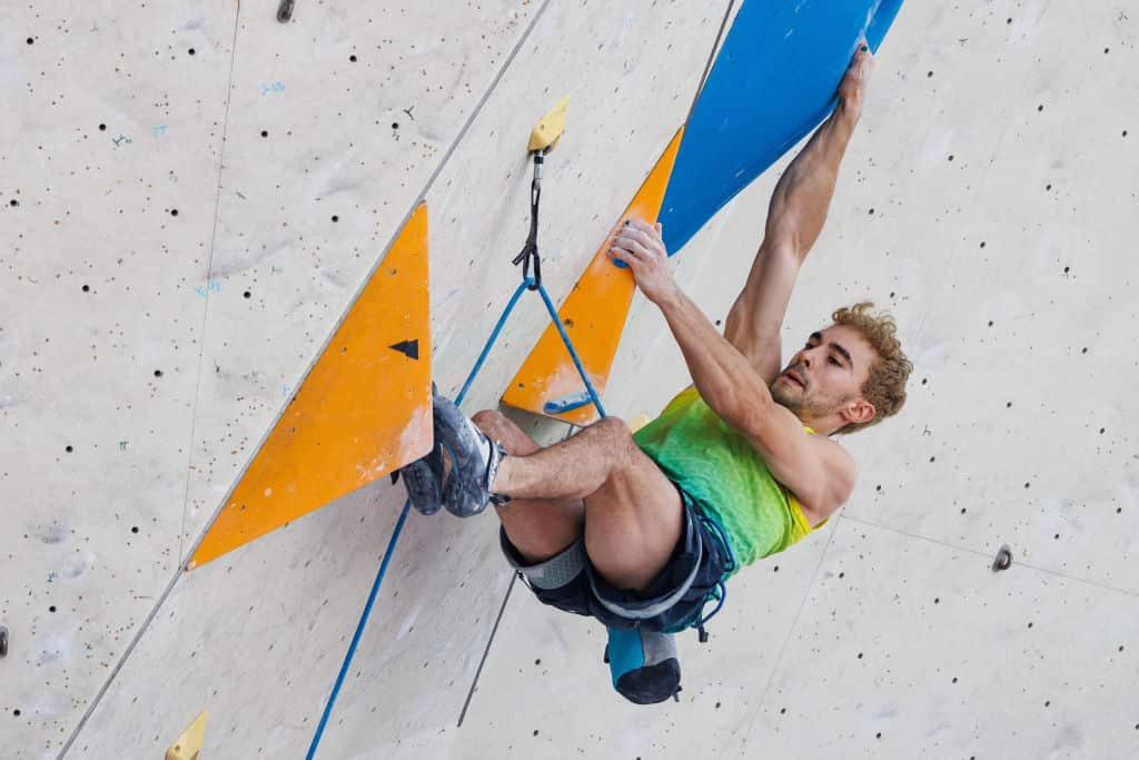 A man attached to a rope on a climbing wall 