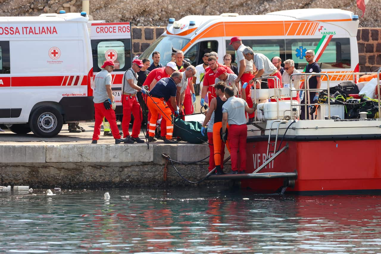 Health workers carry a body bag on the pier.