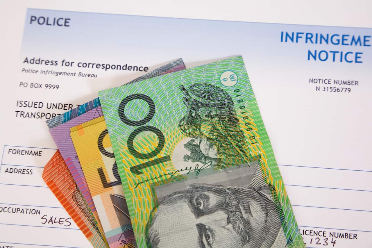 Australian cash notes on top of an infringement notice document.