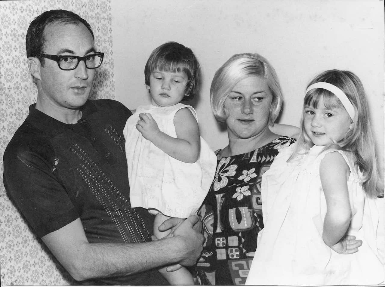 A black and white picture of a man and woman and their two young daughters.