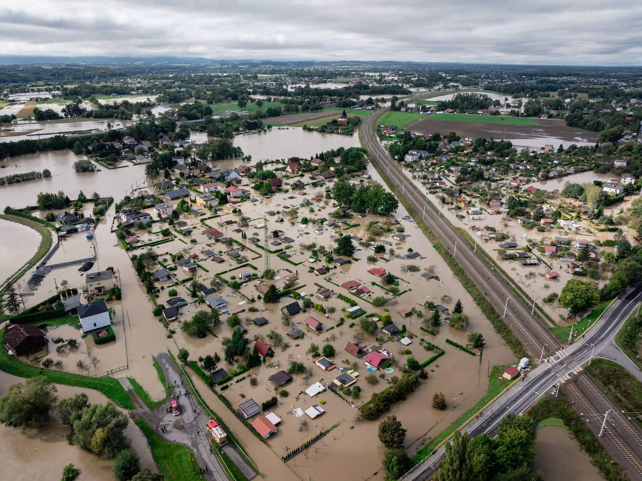 Coloured roofs of houses peaking through murky floodwaters.