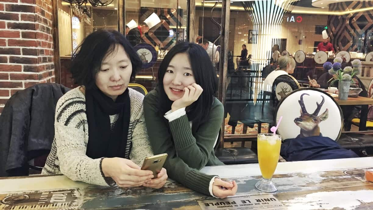 a woman on her phone and her daughter sitting next to her