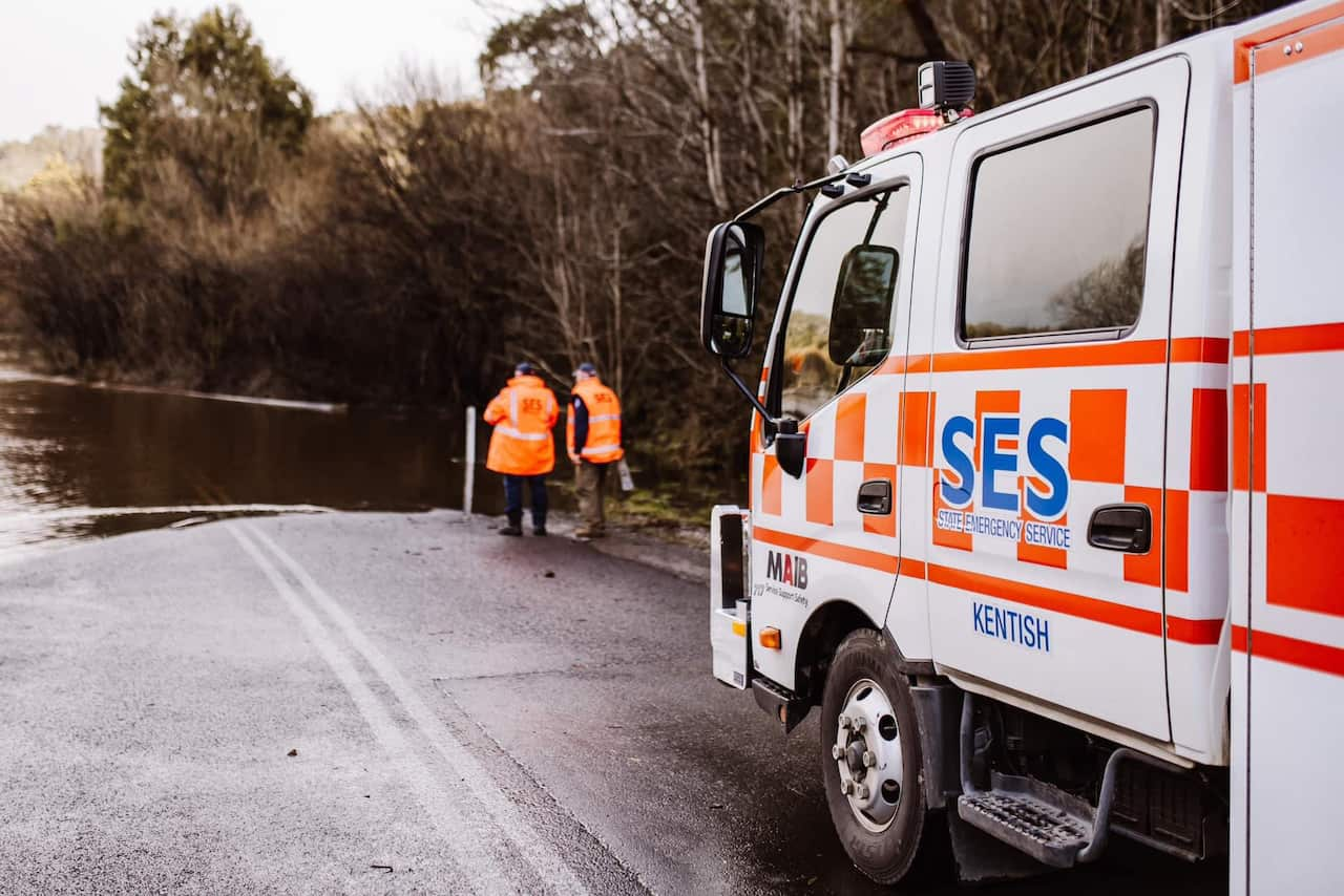 A truck stops at a flooded rood. 