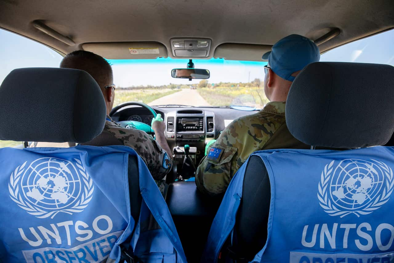 Two men in a car driving through terrain