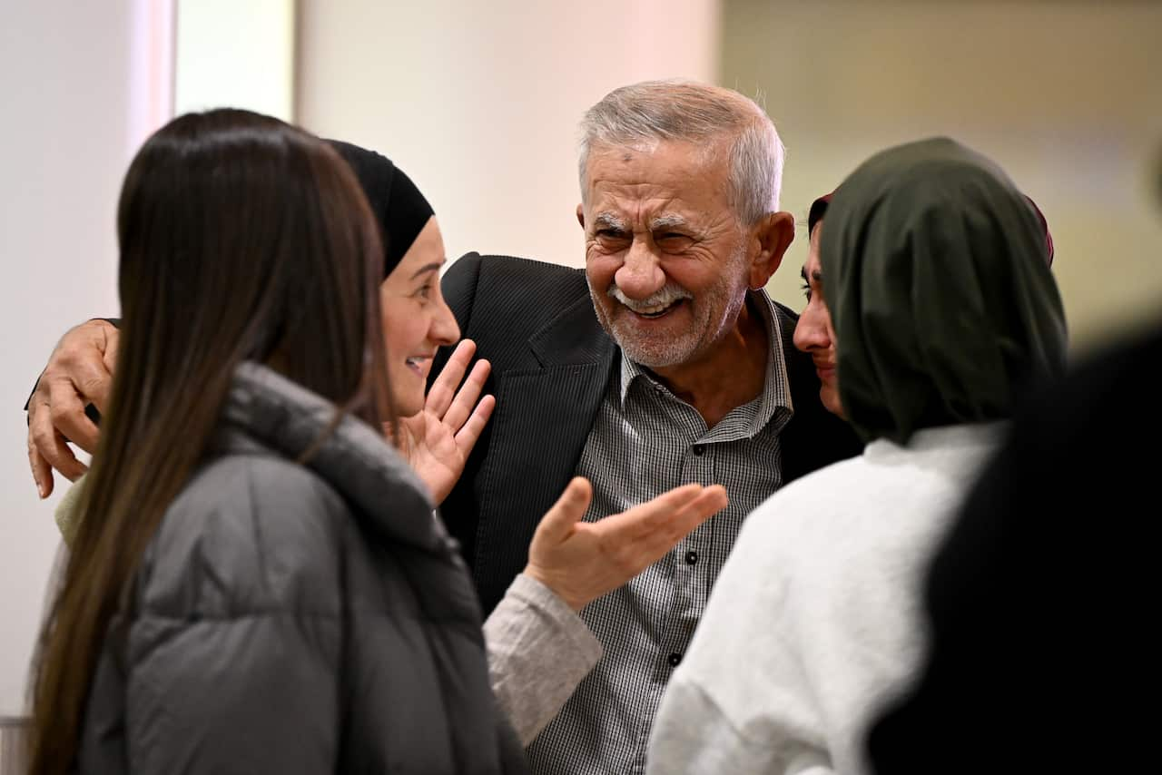 An emotional family embrace at an airport.