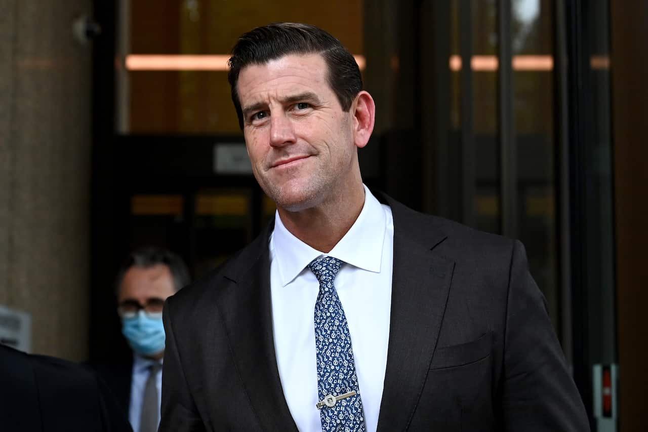 Ben Roberts-Smith in white shit, blue tie and black jacket.