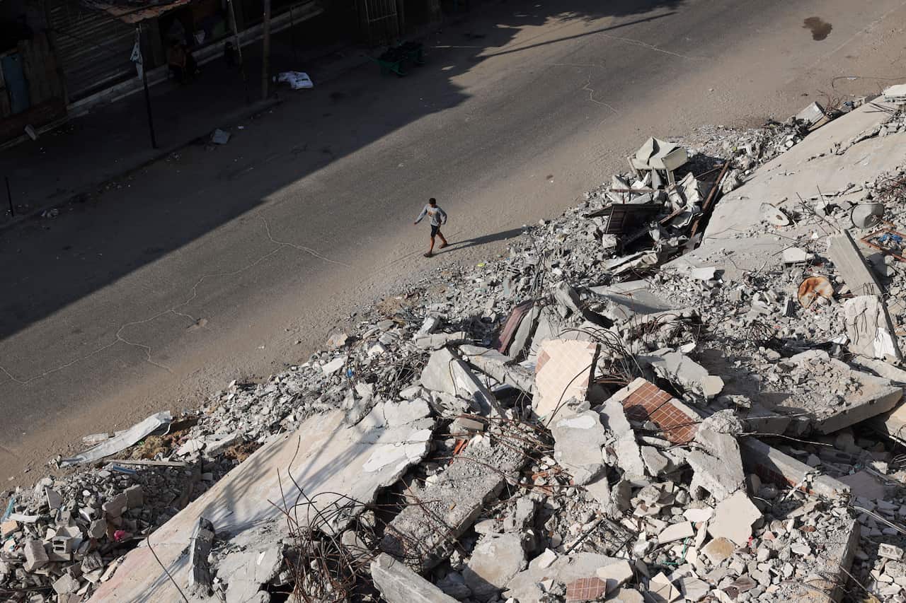 Overhead shot of a person walking down a road surrounded by rubble
