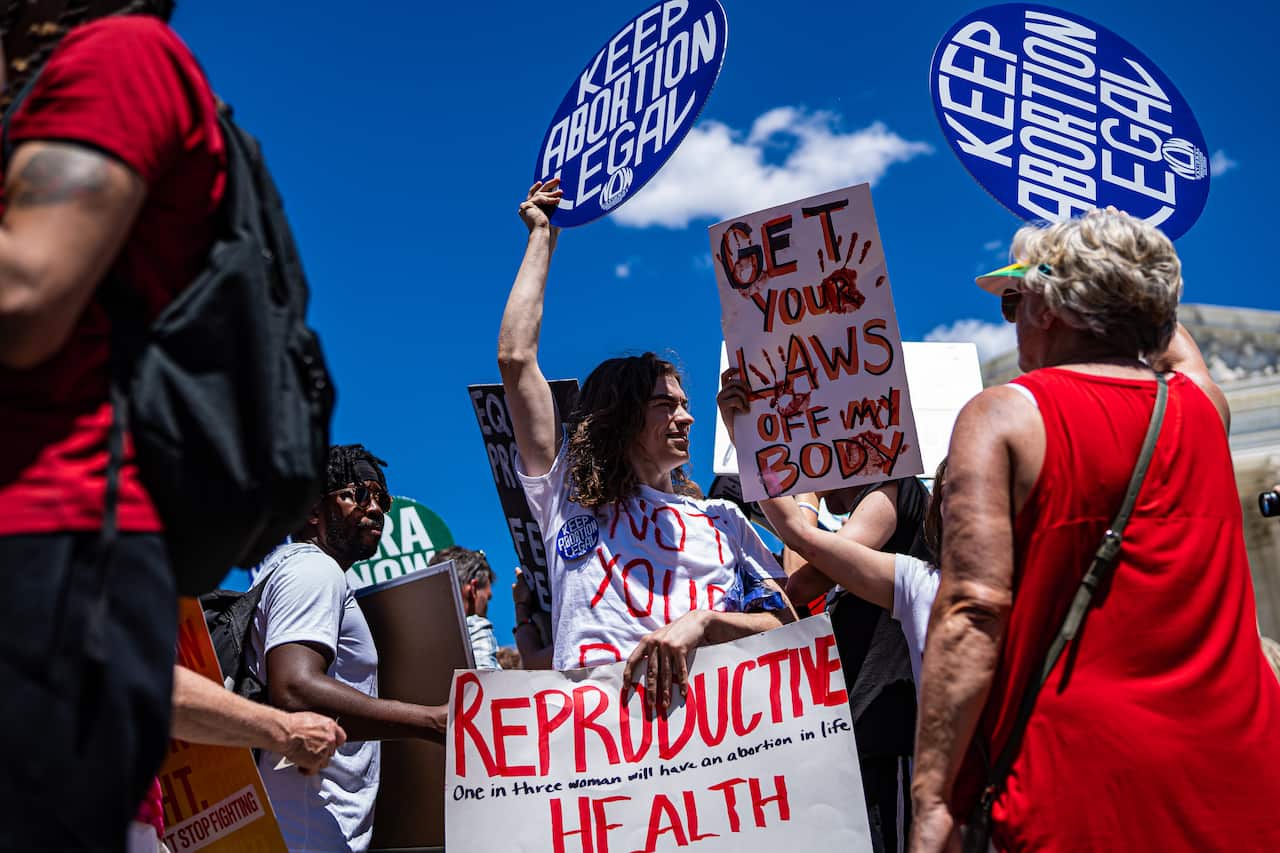 A group of protesters holding up signs for reproductive rights.