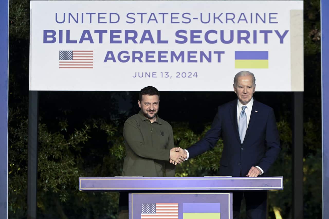 Ukrainian President Volodymyr Zelenskyy shakes hands with US President Joe Biden. 