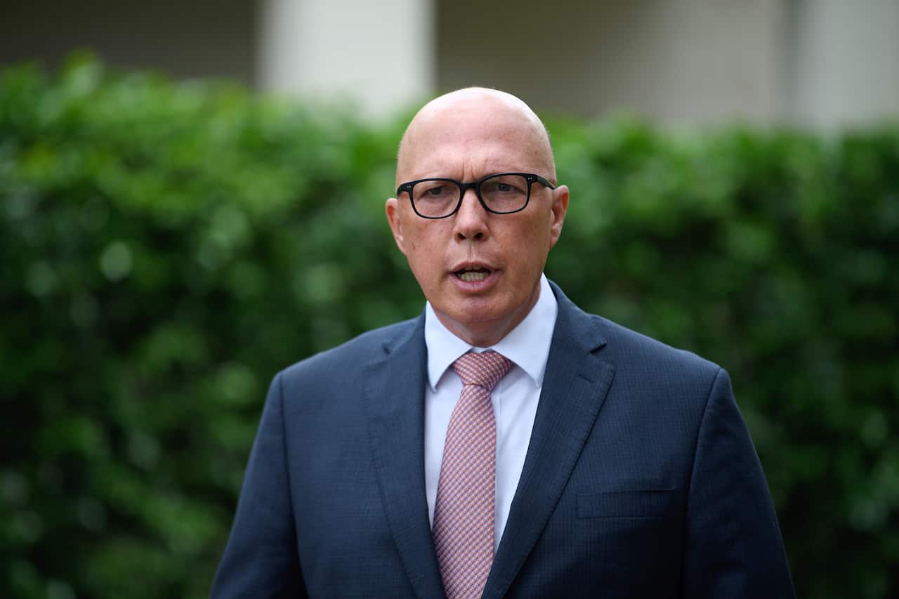 A bald man in a suit wearing glasses. 