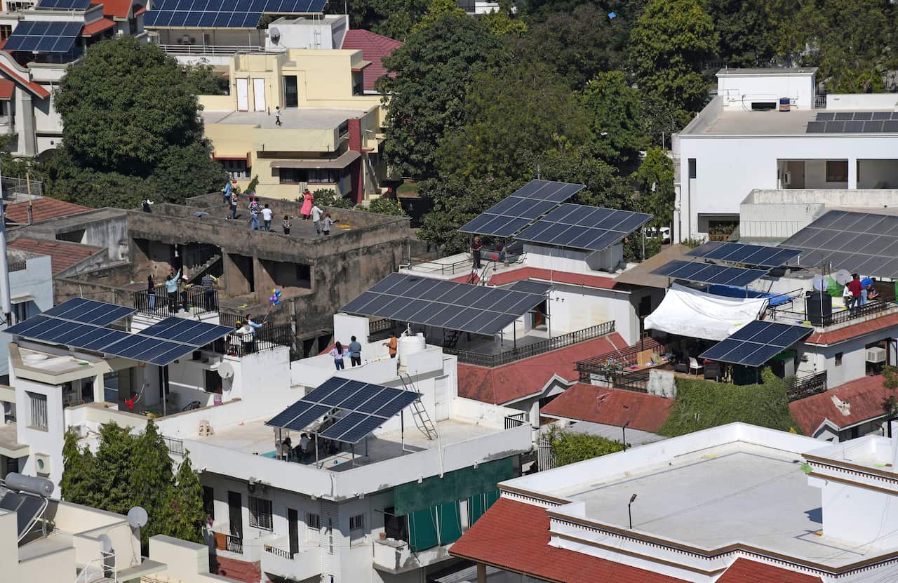 Solar panels are seen on the roof of residential buildings