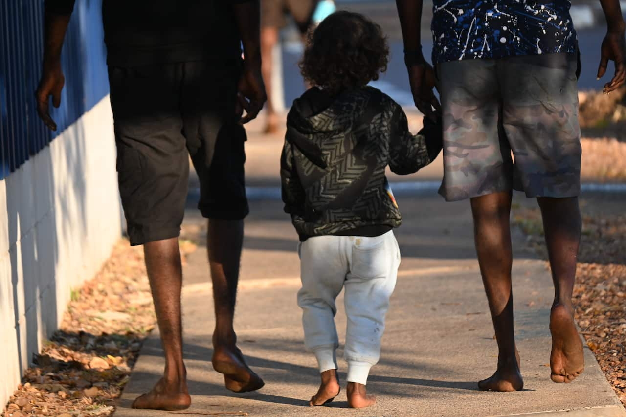 A family leaves the St Vincent de Paul Society centre in Stuart Park, on the fringes of Darwin city