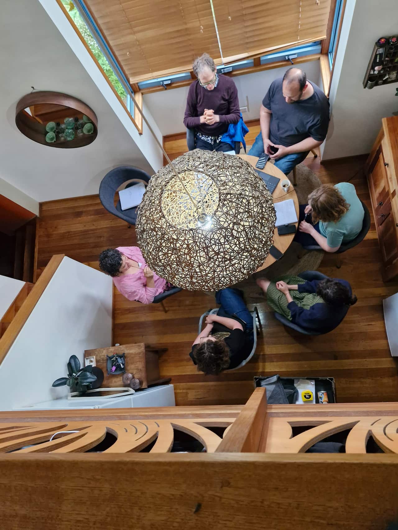 A view from above of six people meeting around a table.