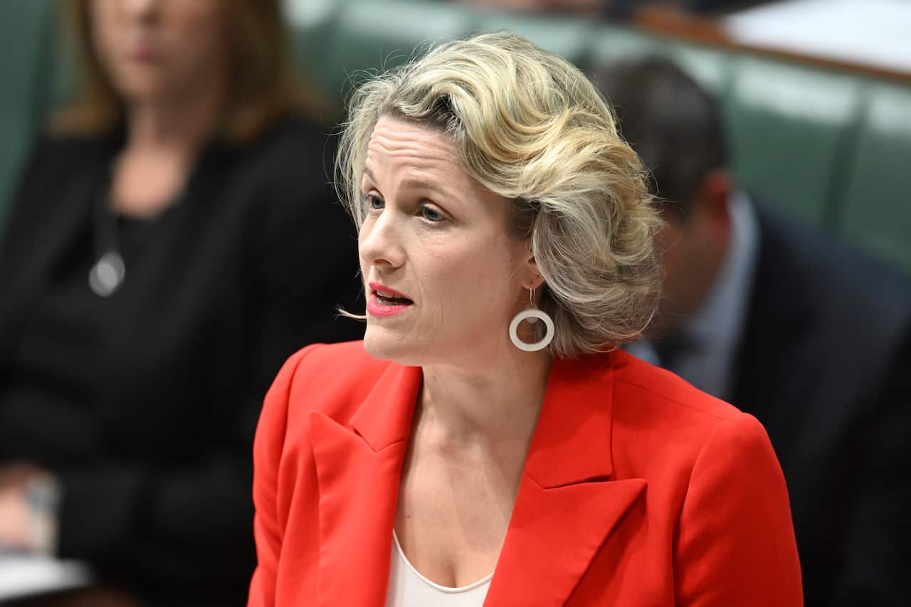 A woman in a red blazer speaks