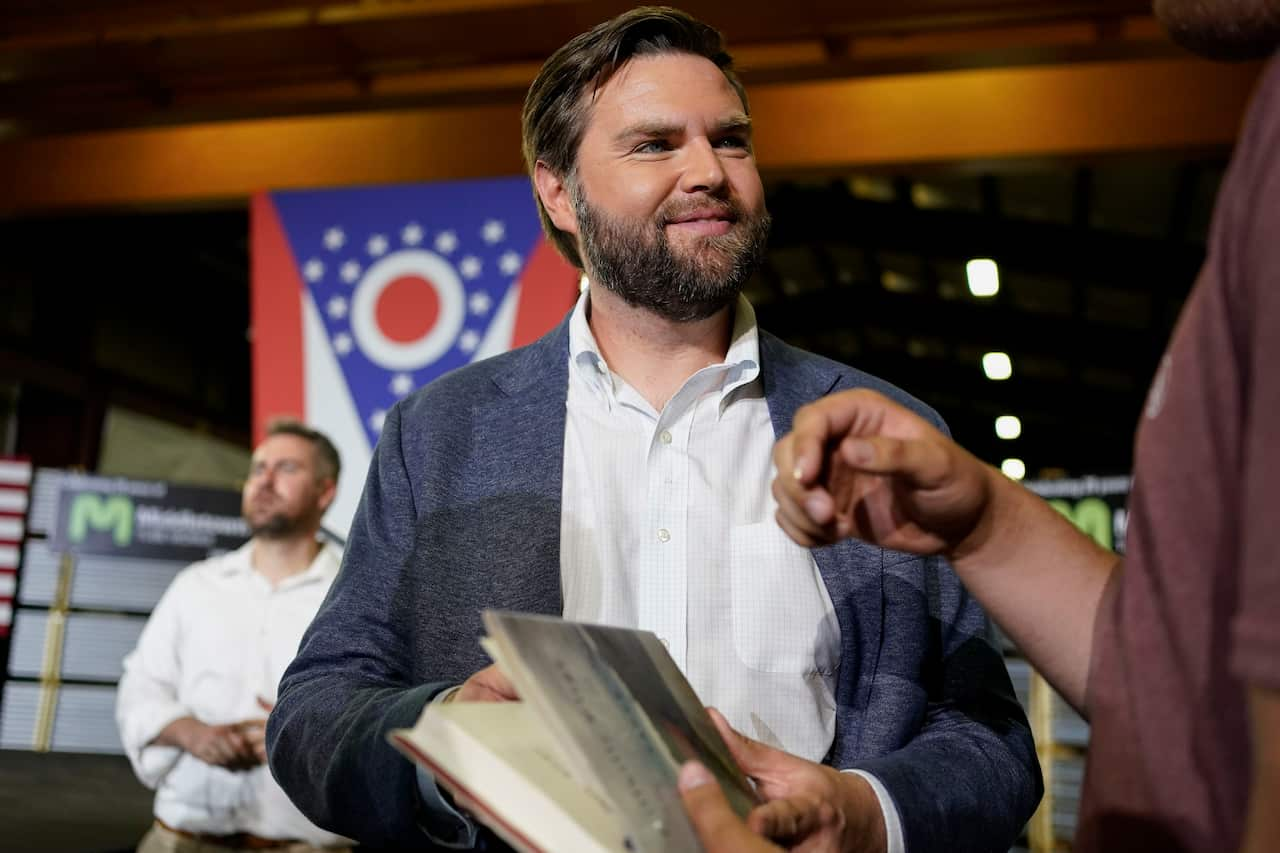 J.D. Vance holding a book.