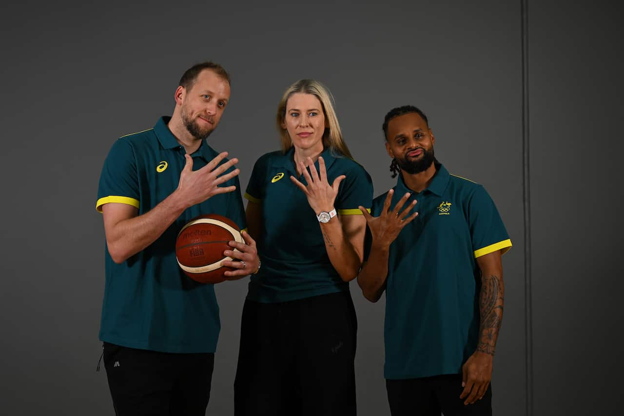 Joe Ingles, Lauren Jackson and Patty Mills wearing Australian shirts and holding up five fingers.