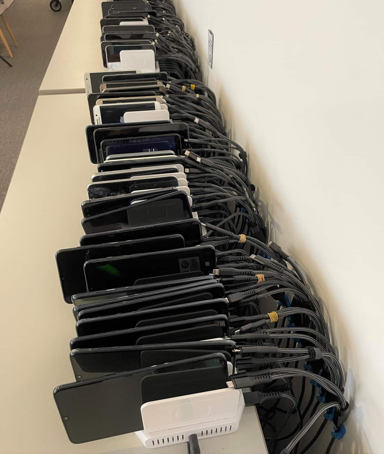 A row of second-hand phones sitting on a shelf.