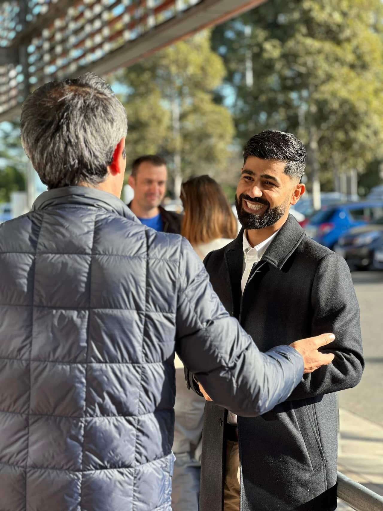 A man smiles looking at another person