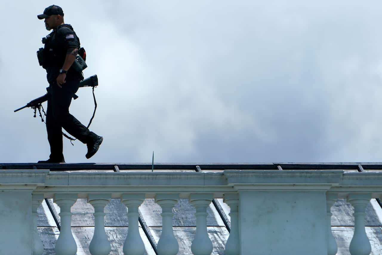 Secret service sniper walks on rooftop