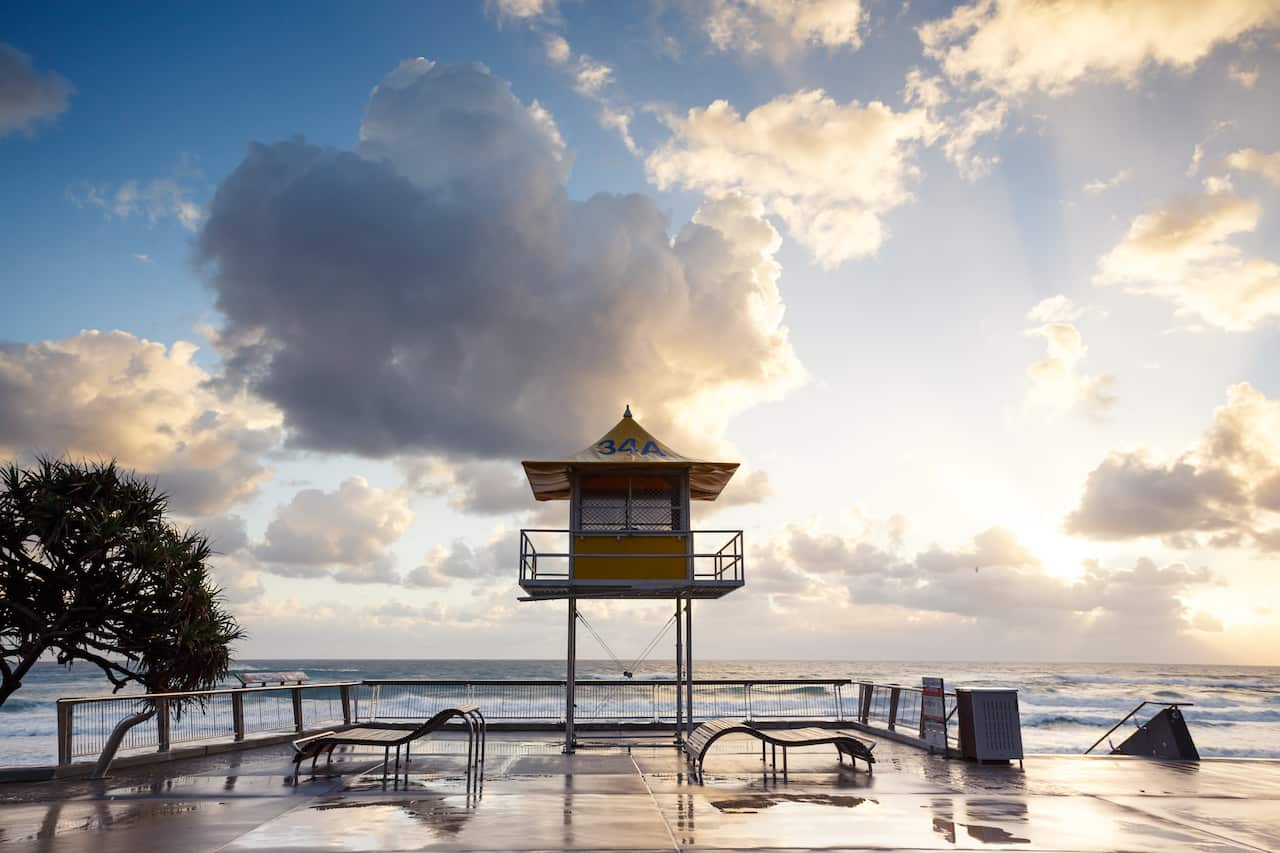 A sunny, cloudy sky overlooks a beach.