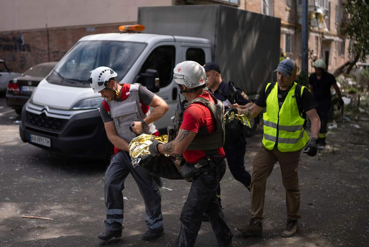 Rescue workers carry the body of a child, killed after Russia's missile attack in Kyiv, Ukraine.