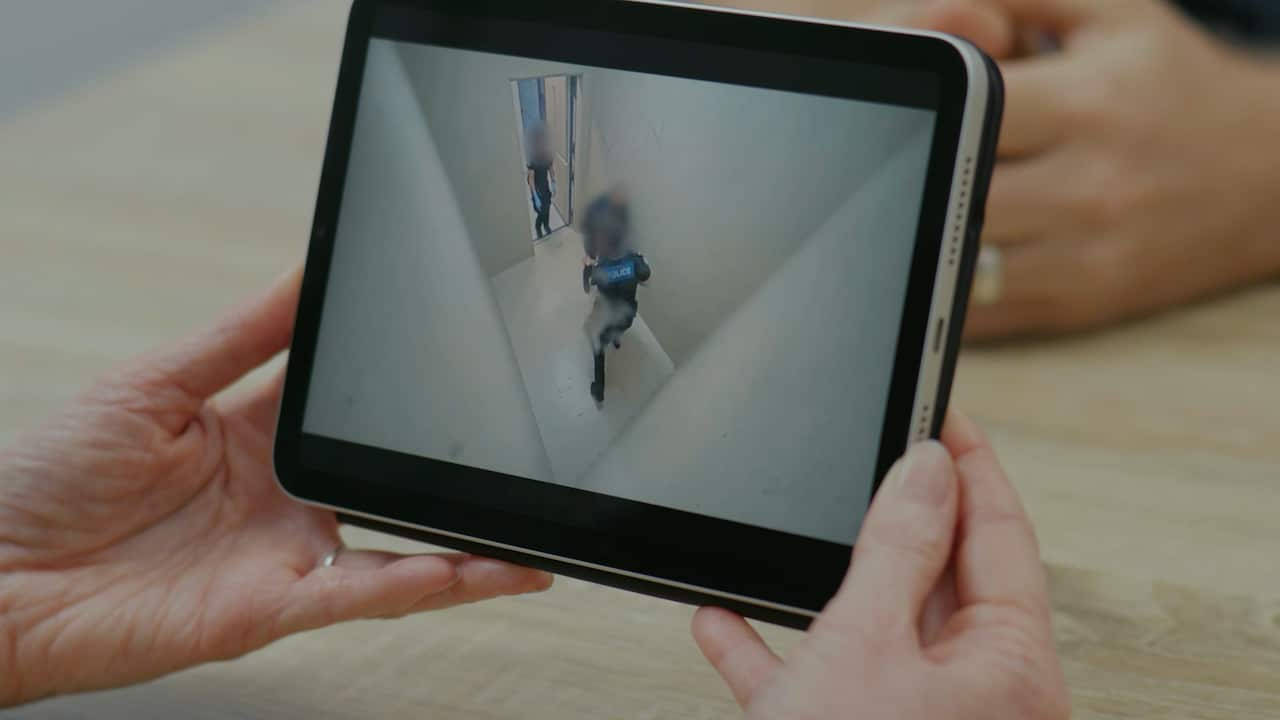 A person holds a tablet and views footage of CCTV.