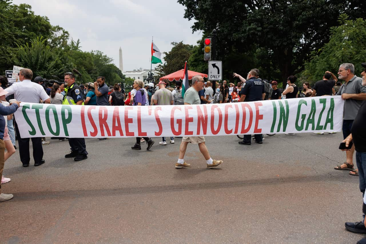 A group of protesters holding a sign.