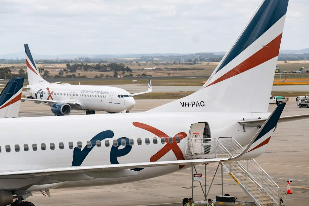 A plane on an airport tarmac with the Rex logo on it.