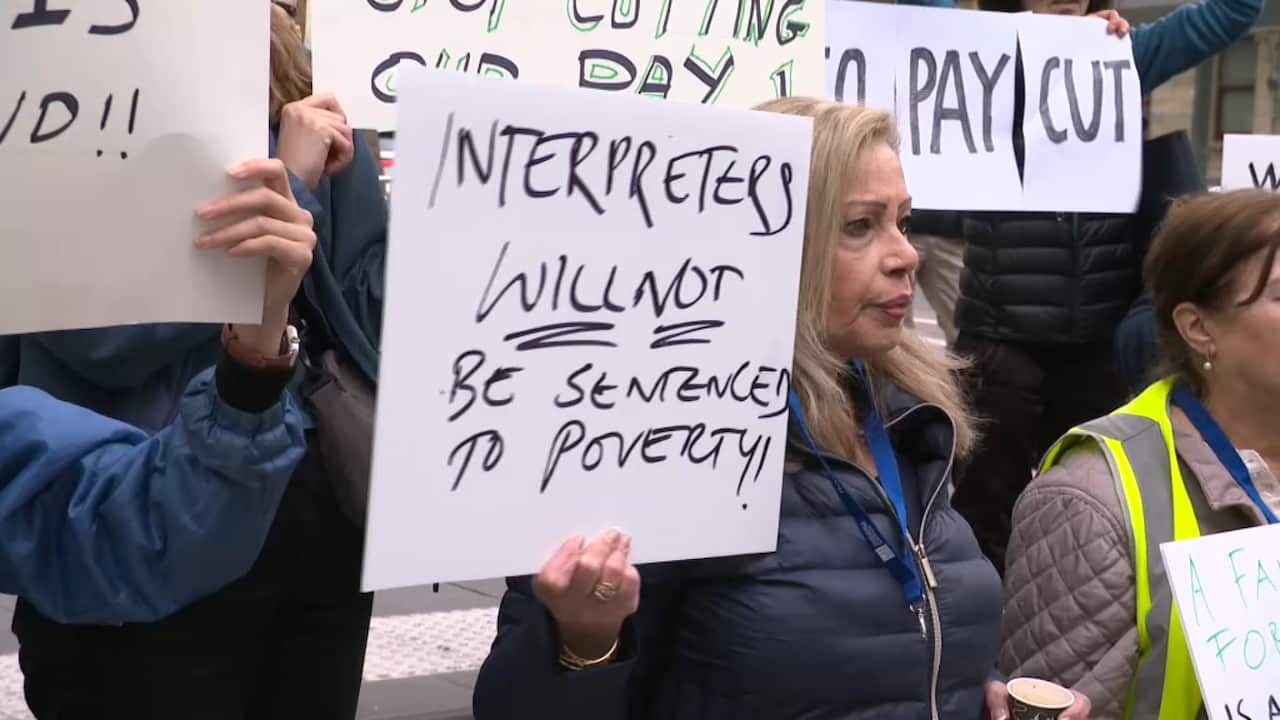 Interpreters at a rally in Victoria, holding signs in front of the County Court in Melbourne.